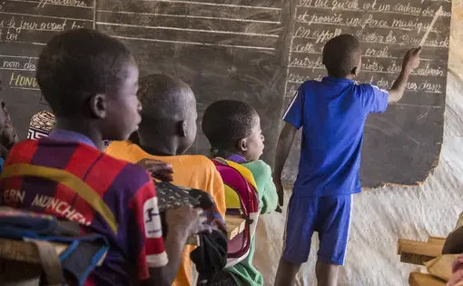 Children learn in a makeshift classroom located in a sprawling camp for thousands of displaced families in the Central African Republic. Image by Jack Losh. Central African Republic, 2018.