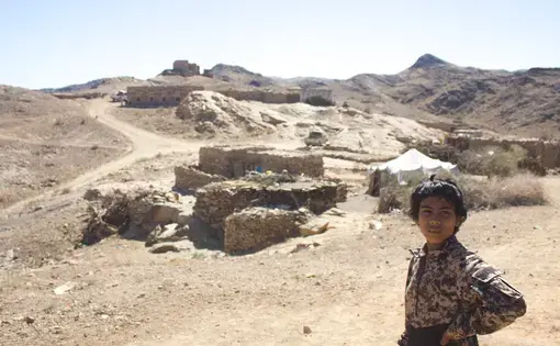 A boy stands in the village of al Ghayil in Yemen where U.S. Navy SEALs, attack helicopters, and drones launched an operation on January 29. Image by Iona Craig. Yemen, 2017.