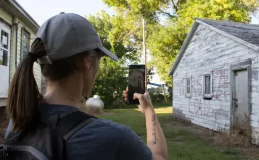Kayla Vondracek photographs a structure preparing to be relocated. Image by University of Nebraska Lincoln. United States, 2020.