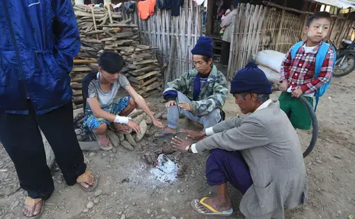 Ethnic Kachin villagers uprooted from their homes by nearby fighting warm themselves by a fire at a displaced persons camp in Myitkyina, Burma. Image by Jason Motlagh. Media file: img_6206_small.jpg