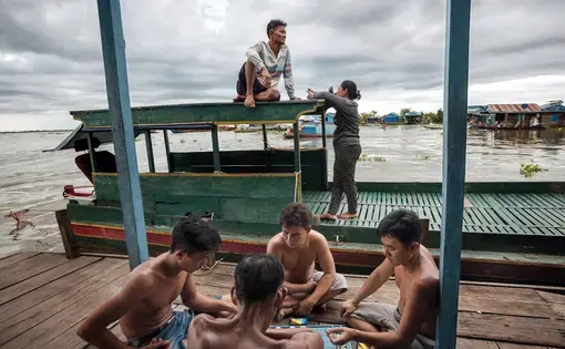 Playing xiangqi on the porch of a floating house in the village of Chhnok Trou. Image by Andrea Frazzetta. Cambodia, 2018.