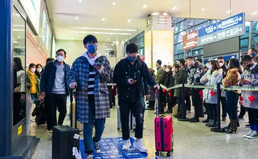Chengdu, Sichuan, China: Travelers wear masks at the airport to prevent infection from coronavirus. Image by B.Zhou / Shutterstock. China, 2020.