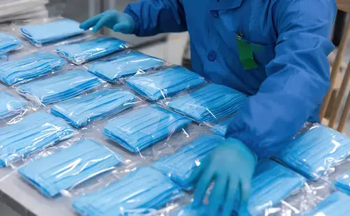 With the global spread of novel coronavirus, medical mask production workers are organizing masks to prepare for the epidemic. Image by InkheartX / Shutterstock.