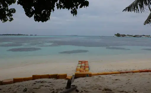 Plastic jerrycans have been staked on the beach of Guraidhoo, Maldives, to protect the shoreline during storm surges. Image by Kai Schultz. Maldives, 2017.