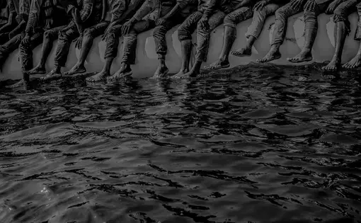 Roughly a hundred and fifty people wait to be rescued from an inflatable dinghy in the Mediterranean Sea, twenty miles north of Libya. The boat left with only enough fuel to reach international waters. Image by Ben Taub. Libya, 2016.