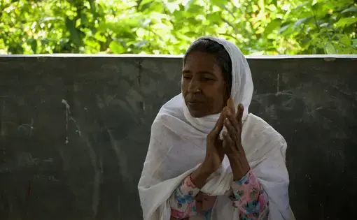 Mustava, 59, sings and plays the harmonium with a band in a Rohingya refugee camp in Bangladesh. “There are people who do not like music, especially when women do it,” she says. “But people like us, we value music because it refreshes our soul.” Image by Sasha Ingber. Bangladesh, 2018.