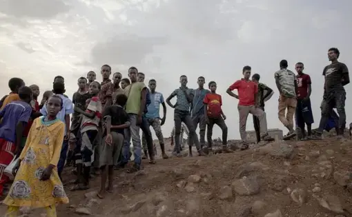Ethiopian migrants stand on a hill at a slum in Dikhil, Djibouti, where they took shelter after entering the country, July 12, 2019, on their journey to Yemen. Most hope to eventually reach Saudi Arabia. Image by AP Photo / Nariman El-Mofty. Djibouti, 2019.