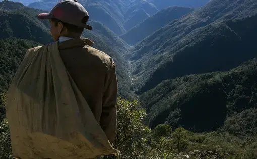 A man pauses above the Captzin River, in the highlands of western Guatemala, on his way home from collecting recyclable materials. Image by Mauricio Lima. Guatemala, 2019.