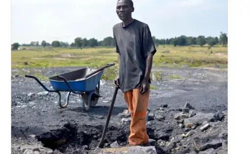 An old man digs coal at an abandoned coal mine in Ermelo, Mpumalanga. Image by Mark Olalde. South Africa, 2017.