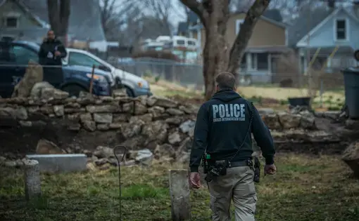 Kansas City, MO Police Officer Aric Anderson, who is part of the police crisis intervention team, looks for a homeless man with mental illness at an abandoned house he is known to stay at. Image by PBS Newshour. United States, 2018.