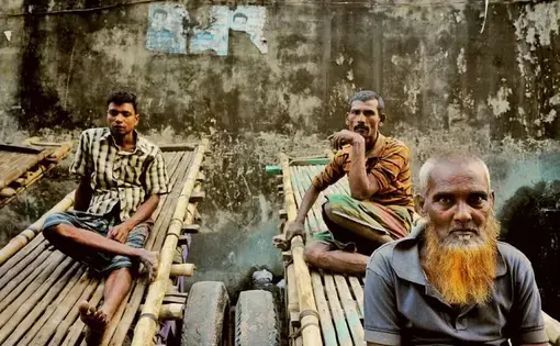 Tannery workers take a break before noon prayers. Their carts can carry a ton of goat skins through the narrow streets of Hazaribagh. Image by Larry C. Price. Bangladesh, 2016.