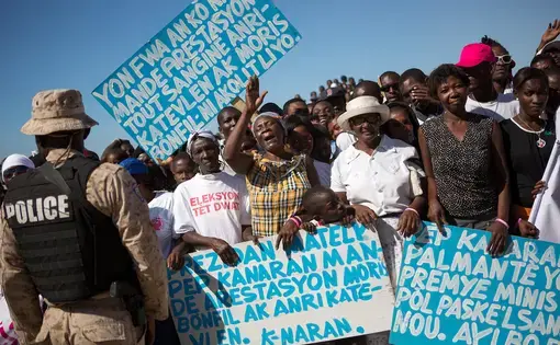 Protesters at a memorial commemorating the five-year anniversary of the 2010 earthquake. Image by Allison Shelley. Haiti, 2016.