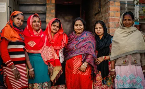A group of female housing rights activists stand in front of their relocation flats in Baprola, New Delhi. Image by Kiran Misra. India, 2019.