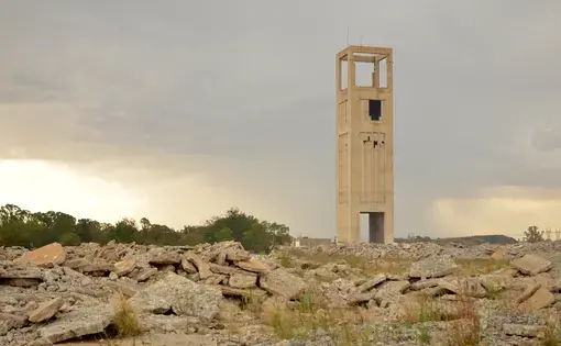 An abandoned gold mine shaft rises from the ruins of a mine in Welkom, Free State. Image by Mark Olalde. South Africa, 2017.