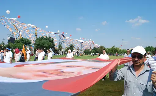 Supporters of the Justice and Development Party carry a flag depicting Prime Minister Recep Tayyip Erdogan at a 2013 rally. Image by Jenna Krajeski. Turkey, 2014. Media file: dsc_0133.jpg