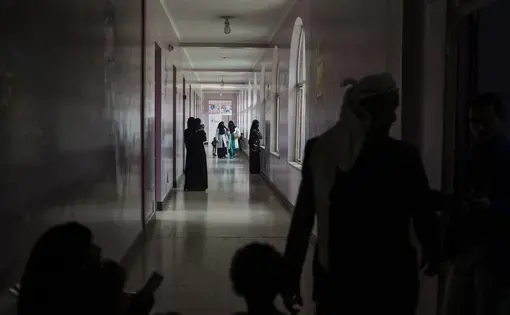 Yemeni families and nurses walk through the malnutrition wing at Sabaeen Hospital in Sanaa on May 4, 2018. Most hospitals in the north are functioning at minimal levels, constantly short on supplies, while their staff have remained unpaid for months. Image by Alex Potter. Yemen, 2018.