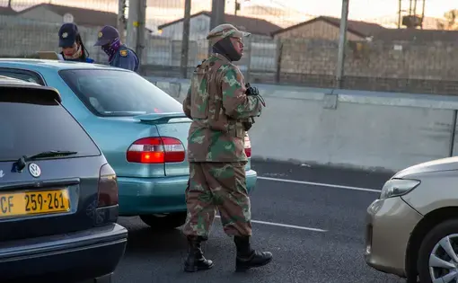 Members of the South African Police Service and the South African National Defence Force deploy at a roadblock on the busy R300 highway. Image by Roger Sedres / Shutterstock. South Africa, 2020.