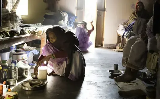 Elderly widows cook next to their beds at Tarash Mandir, a short-stay home for young women and permanent facility for elderly widows in Vrindavan. Image by Amy Toensing. India, 2016.