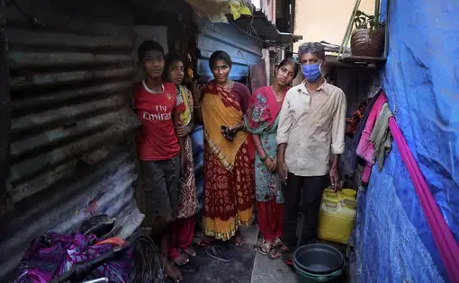 Mina Ramesh Jakhawadiya, center, poses for a picture with her family members outside her one room house in a slum in Mumbai. Image by AP Photo/Rajesh Kumar Singh. India, 2020. Mina Ramesh Jakhawadiya, center, poses for a picture with her family members outside her one room house in a slum in Mumbai. Image by AP Photo/Rajesh Kumar Singh. India, 2020.