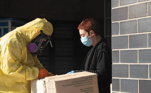 A men in a full protective suit delivers supplies to Elmhurst Hospital due to COVID-19 outbreak on March 26, 2020 in Queens neighborhood of New York City. Image by Ron Adar / Shutterstock. United States, 2020.