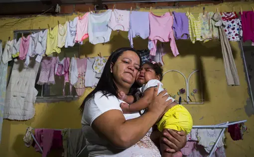 Fabiane Lopes holds her daughter, Valentina at their home in Duque de Caxias, a suburb of Rio de Janeiro in southeastern Brazil. Valentina's mother was pregnant when she became infected with the Zika virus and her daughter was born with microcephaly—a congenital malformation with smaller than normal head size for age and sex as well as other profound birth defects. Brazil has confirmed far more malformations of the brain in babies born to mothers who were infected with Zika than any other country. After…