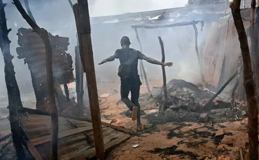 A neighborhood in the capital, Bangui, smolders in 2014 after Christian-led militias attacked predominantly Muslim rebels who had ousted the government. The faiths once coexisted in relative peace, but chaos has reigned in much of the nation for the past four years. Image by Marcus Bleasdale. Central African Republic.