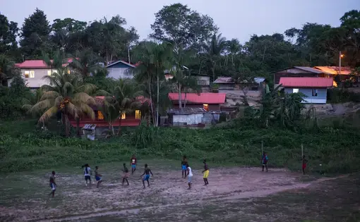 People play soccer as dusk falls on the village of Adjuma Kondre in Suriname. The village's water sources have been impacted by Alcoa's nearby mining operations. Image by Stephanie Strasburg. Suriname, 2017.