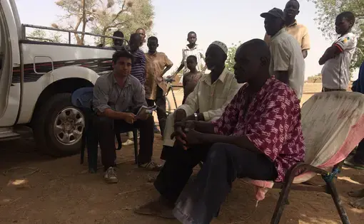 Journalist Chris Arsenault talks with residents of a village inside the Malibya concession. Many worried they could be displaced if the project starts again. Image by Chris Arsenault. Mali, 2015. Media file: img_0565.jpg