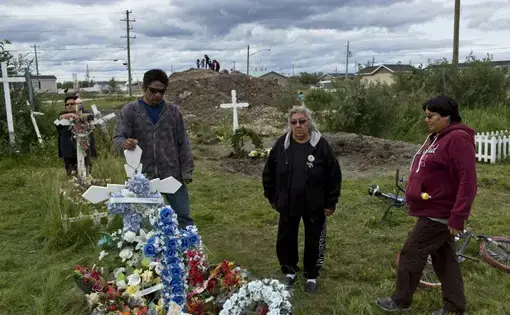 Members of the Attawapiskat First Nation community gather in the St. Mary’s cemetery to visit the graves of loved ones. Despite the loss, there was a sense of connection and strength from the families, a testament to the resilience of the Cree people. Image by David Maurice Smith/Oculi. Canada, 2016.