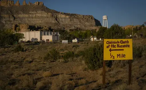 A hand-painted sign points the way to the Chilchinbeto Church of the Nazarene in Chilchinbeto, Ariz., on the Navajo reservation at sunrise on Sunday, April 19, 2020. The Navajo reservation has some of the highest rates of coronavirus in the country. If Navajos are susceptible to the virus' spread in part because they are so closely knit, that's also how many believe they will beat it. Image by AP Photo/Carolyn Kaster. United States, 2020.
