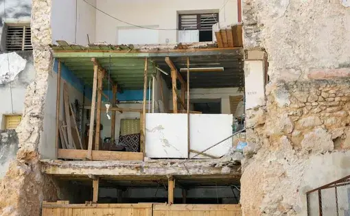 A chunk of Juan Pío Balboa's apartment crashed to the ground. His kitchen and bedroom wall had collapsed, leaving a gaping hole in the building. Image by Tracey Eaton. Cuba, 2019.