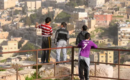 Group of local Jordanian children and city skyline out of focus from the Citadel Hill, Jabal. Image by Thiago B Trevisan / Shutterstock.com. Jordan, 2018.