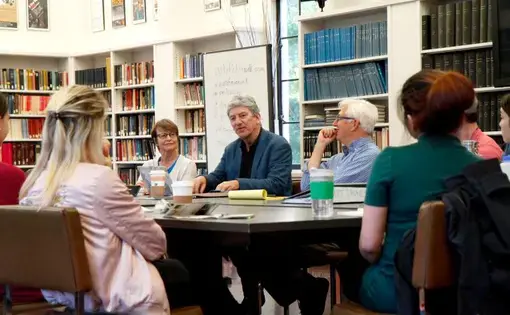 Don Belt (center), professor and university outreach director for the "Out of Eden" project, speaks to students and lecturers about international journalism at University of California, Berkeley. Image by Lauren Shepherd. United States, 2017.