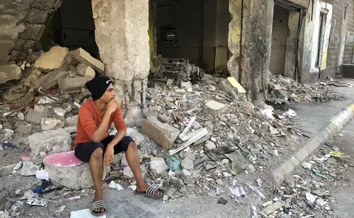 Moaad sits in the rubble of his home in the Kraytar district of Aden, hit so hard during the 2015 battle between government forces and Houthi rebels. Three years after the battle, this neighborhood, like so many in Aden, has never been rebuilt. Image by Marcia Biggs. Yemen, 2018.