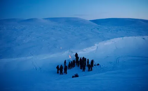 NATO soldiers and airmen learn how to carve a temporary shelter into drifted snow at the Canadian military’s Chrystal City training facility near Resolute Bay in Nunavut. Image by Louie Palu. Canada, 2018.