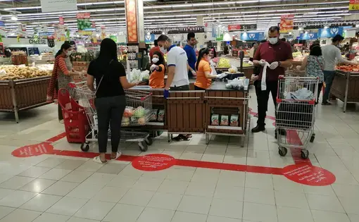 A supermarket stipulates social distancing for customers during the novel coronavirus pandemic outbreak. Image by Arnold O. A. Pinto / Shutterstock.com. United Arab Emirates, 2020.