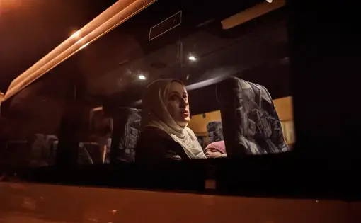 After an exhausting day-long flight, Syrian refugee Taimaa Abazli takes a bus from Talinn, Estonia, to her new home in rural Polva, a village of 6000 people. Photo by Lynsey Addario. Estonia, 2017.