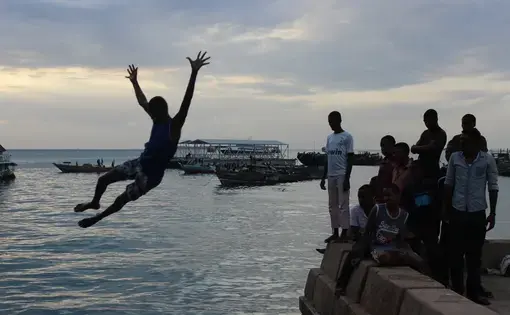 Jumping off the cement perimeter into the ocean at Forodhani Gardens is a nightly event for young boys in Stone Town, Zanzibar. Image by Claire Elizabeth Felter. Tanzania, 2015. Media file: img_0322.jpg
