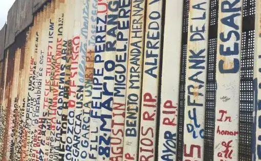 The names of deported veterans were painted in the wall that separates Tijuana, Mexico and San Diego. Image by Maria Ines Zamudio. United States, 2019.