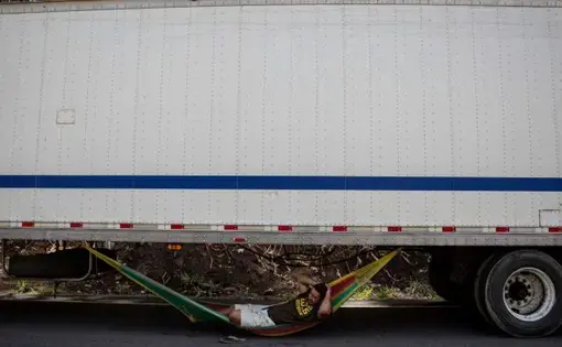 There is a constant image that extends along 17 km accumulated of trucks: that of a driver lying in his hammock. Luis Aguilar kills time, like hundreds of his colleagues. Image by César Arroyo. Nicaragua, 2020.