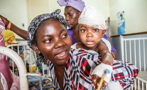 Jacqueline, 2., just comes from the operating room. She suffered severe burns and underwent second surgery at Kamuzu Central Hospital in the capital of Malawi Lilongwe. Her mother Eliza has good hope that she will be healthy again soon. Image by Nathalie Bertrams. Malawi, 2017.