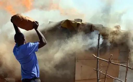 A shack fire breaks out in the Zamimpilo informal settlement. Poor living conditions complicate efforts to link mine waste to health issues. Image by Mark Olalde. South Africa, 2017.