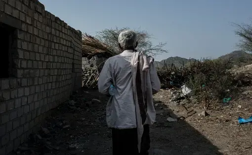 A Yemeni man walks through the rubble of a wedding tent. Image by Alex Potter. Yemen, 2018.