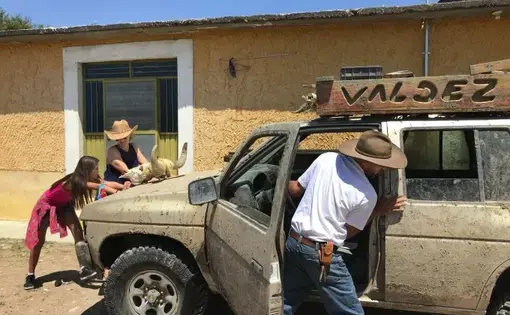 Maya, Joy and Rafael Valdez push their SUV to get it started after the battery died. They use the vehicle in the countryside while sharing the roads. Image by Nina Shapiro / The Seattle Times. Mexico, 2019. 