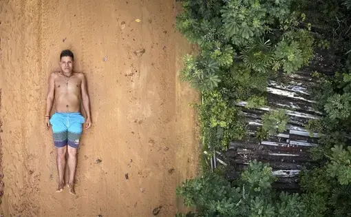 Ednei poses on the tracks left by the trucks used to transport wood that pass through the borders of his territory. Right: what's left of 26 trees destroyed by illegal lumberjacks in indigenous Maró territory. Image by Pablo Albarenga. Brazil, 2019.