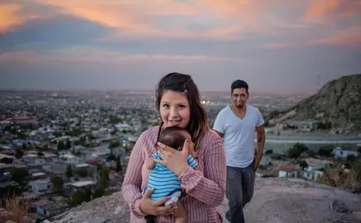 Denise Fuentes and Ulises Escobedo, posing on an overlook with baby Eros, both were touched by the drug war that raged in the neighborhood below. Now they’re searching for a home there. Image by Dominic Bracco II. Mexico, 2015.