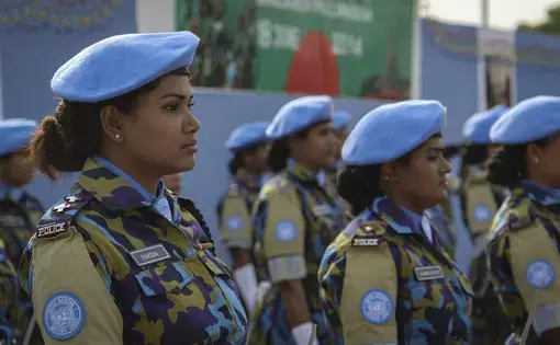 Farida Parveen, a foot soldier from Bangladesh, stands in line.