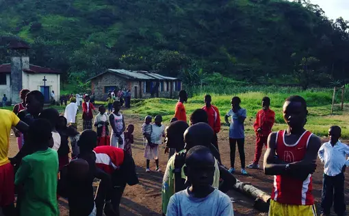 Runners gather early on Sunday morning for a community race at the makeshift soccer field in Kirotshe.