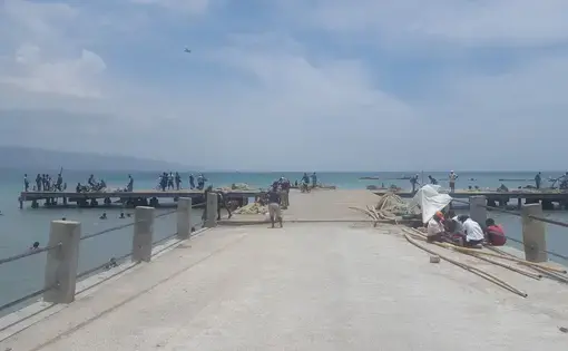 People work and play at a dock in Cite Soleil, near Port-au-Prince, Haiti. Few people in the community have access to safe sewage facilities. Image by Rebecca Hersher. Haiti, 2017.