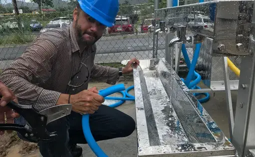 Joachim Alonso, co-founder of Rayo De Luna, makes the finishing touches on a water tower. Image by Tomas Woodall Posada. United States, 2018.